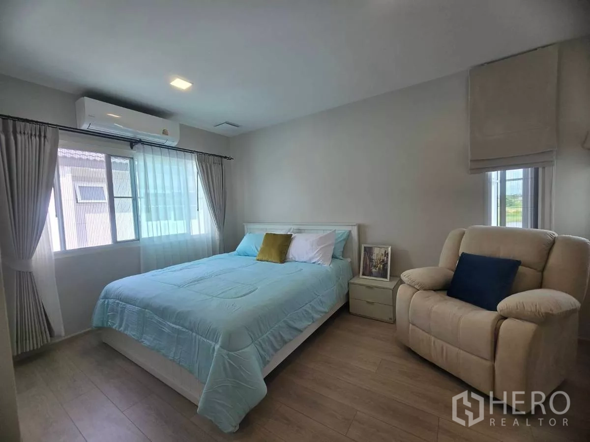 Detached House for rent in Bang Phli, Samut Prakan - Second bedroom with double bed, reclining chair and bright windows.