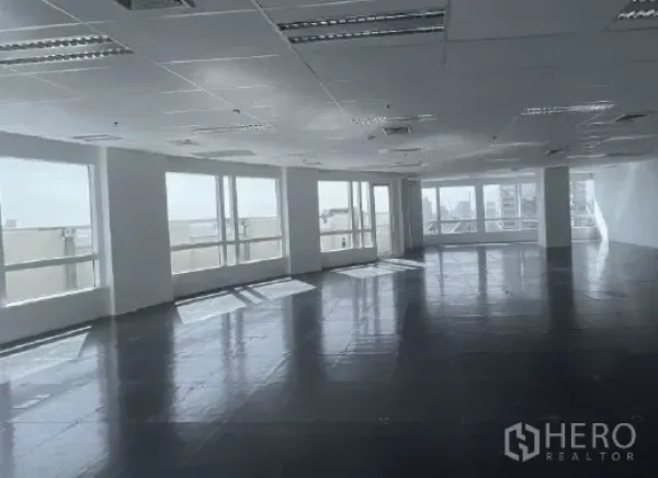 Office Space for rent - Sunlit open office with wide windows and a glass door along the window line, ready for custom fit-out.