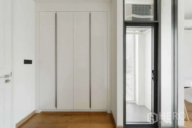 ทาวน์เฮาส์ ให้เช่าหรือขายในWatthana, Bangkok - โถงทางเดินมีตู้เสื้อผ้าบิลท์อินและประตูกระจกสไลด์สู่ระเบียงเล็ก