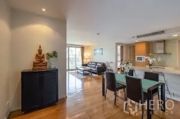 Condominium for rent in Bang Rak, Bangkok - Open-plan dining area beside the lounge with wood floors and soft downlights.
