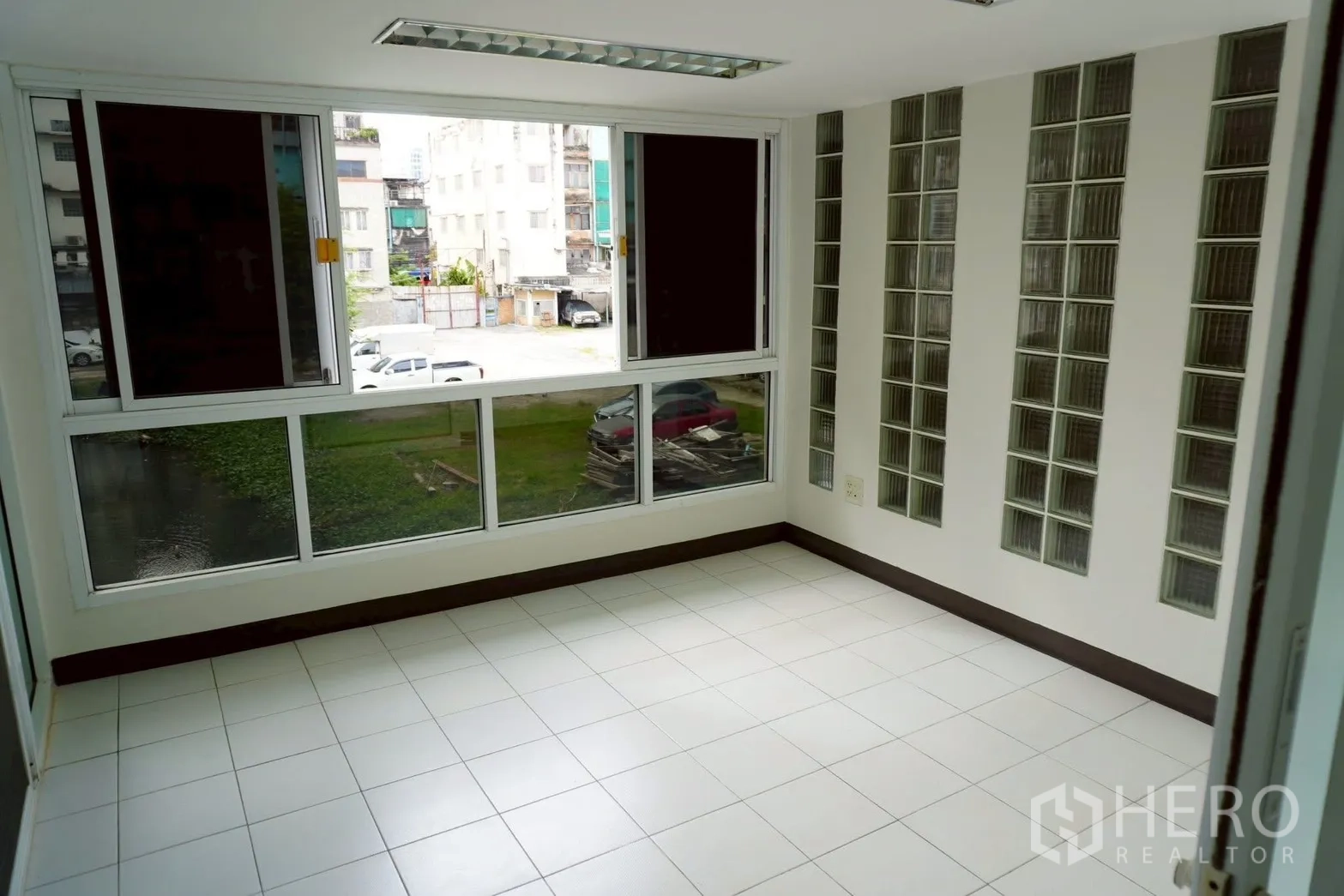 带办公室的家 for rent in Watthana, Bangkok - 转角办公室，玻璃砖点缀，窗外临河与停车区。