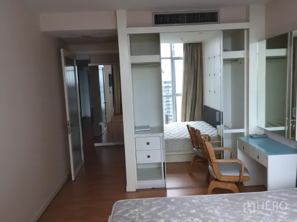 Condominium for rent in Sathon, Bangkok - Bright bedroom with built-in wardrobe, vanity and city-view window in a Sathon condo.