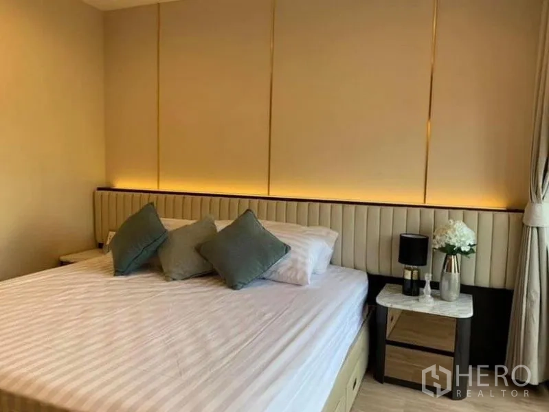 คอนโด ให้เช่าในPathum Wan, Bangkok - ห้องนอนอบอุ่น หัวเตียงบุผ้า โต๊ะข้างเตียง โคมไฟ และไฟซ่อน