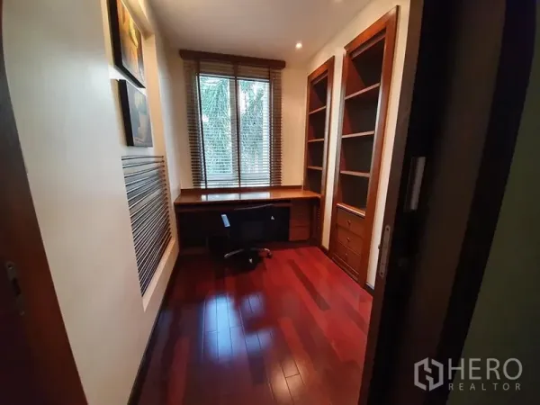 Detached House for rent in Wang Thonglang, Bangkok - Compact home office with built-in desk and shelving, wood flooring and a window.