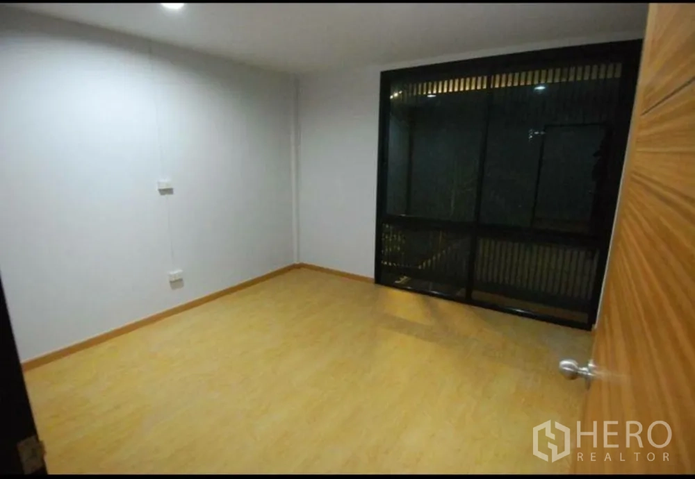 สำนักงานที่บ้าน ให้เช่าในLat Phrao, Bangkok - ห้องนอนอบอุ่น พื้นไม้และกรอบหน้าต่างสีเข้มพร้อมแผงบังสายตา