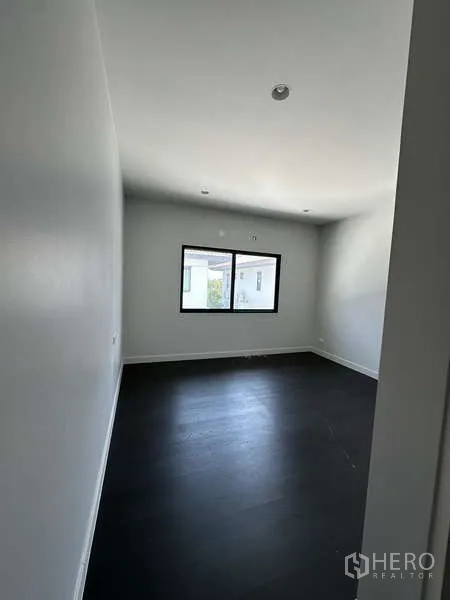 บ้าน ขายในLam Luk Ka, Pathum Thani - ห้องนอนขนาดกะทัดรัดมีหน้าต่าง พื้นไม้เข้ม