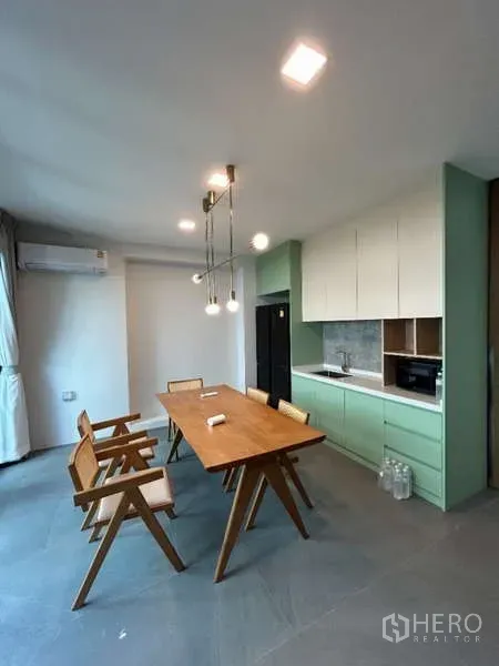 Detached House for rent in Saphan Sung, Bangkok - Compact kitchen with mint cabinetry, wood dining table and pendant lights.