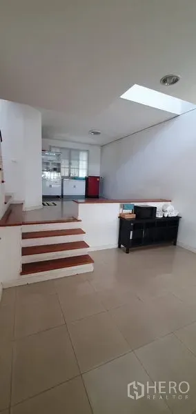 联排别墅 出售在Bang Kapi, Bangkok - 室内错层空间，瓷砖地面，台阶通向采光良好的厨房与天窗。
