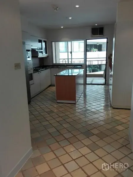 คอนโด ให้เช่าในKhlong Toei, Bangkok - ห้องครัวสว่างพร้อมไอส์แลนด์ เครื่องใช้บิวท์อิน พื้นกระเบื้อง และมุมมองไปยังระเบียง