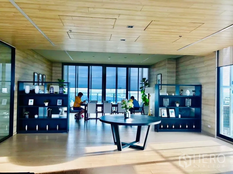 คอนโด ให้เช่าในKhlong Toei, Bangkok - เลานจ์พักผ่อนของโครงการ เพดานไม้ ชั้นวางของ และหน้าต่างบานใหญ่รับวิวเมือง พร้อมโต๊ะกลม