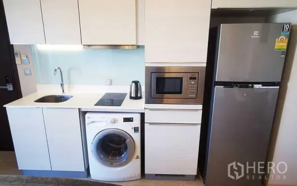 Condominium for rent in Watthana, Bangkok - Built-in kitchenette with sink, induction cooktop, washing machine, microwave and refrigerator.