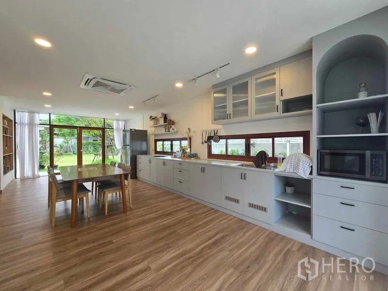 สำนักงานที่บ้าน ให้เช่า - ครัวรูปทรงยาวหันสู่สวน มีกระจกเต็มสูงและชุดโต๊ะทานอาหาร