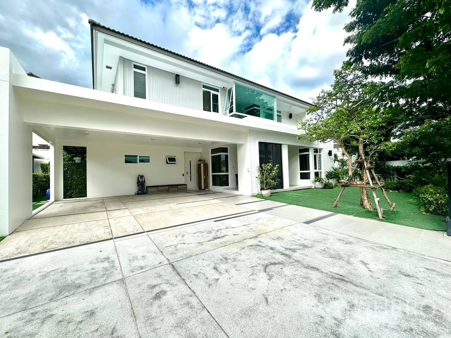 บ้านเดี่ยว for rent in Bang Phli, Samut Prakan - ด้านหน้าบ้านมีระเบียงกระจก โรงจอดรถ และลานคอนกรีตกว้าง.