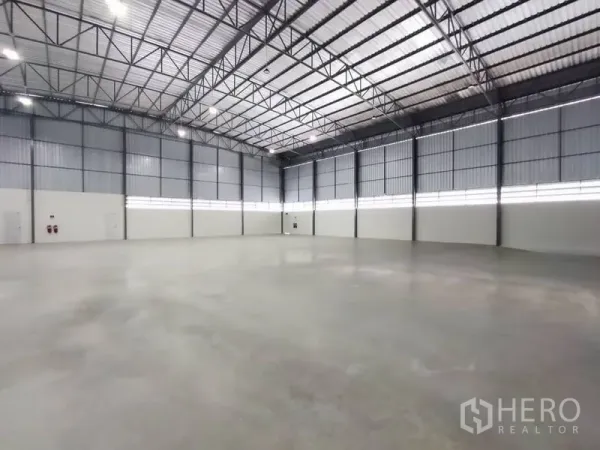 Warehouse for rent in Bang Phli, Samut Prakan - Spacious warehouse interior with high steel truss ceiling and polished concrete floor.