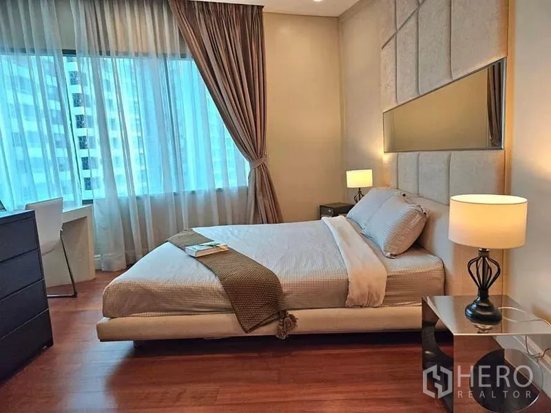 คอนโด ให้เช่าหรือขายในKhlong Toei, Bangkok - ห้องนอนอบอุ่น เตียงหัวเตียงบุผ้า โคมไฟหัวเตียง และหน้าต่างบานใหญ่พร้อมผ้าม่าน