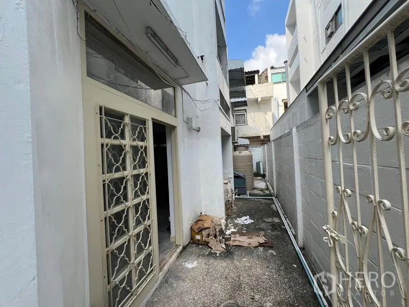 Home Office for rent in Watthana, Bangkok - Narrow side yard with metal security gate and service area.