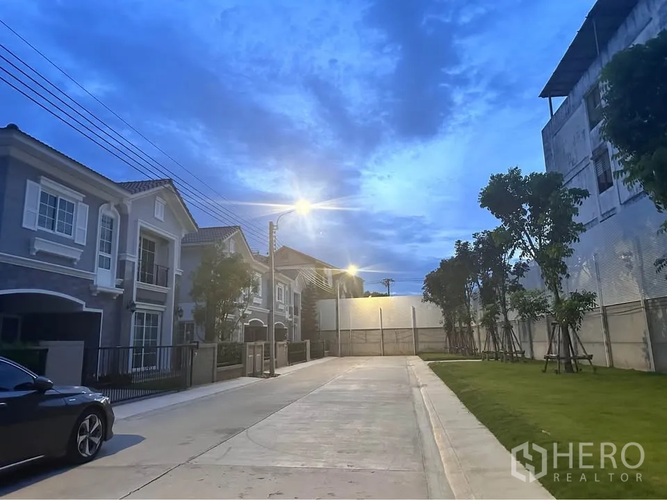 บ้านแฝด for rent in Mueang Samut Prakan, Samut Prakan - ถนนในโครงการเงียบสงบ มีบ้านเรียงราย ต้นไม้ และไฟถนนยามค่ำ