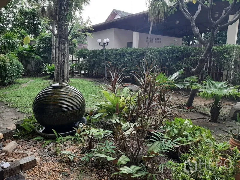 Home Office for sale in Phra Khanong, Bangkok - Lush tropical garden with round water feature and shaded trees.