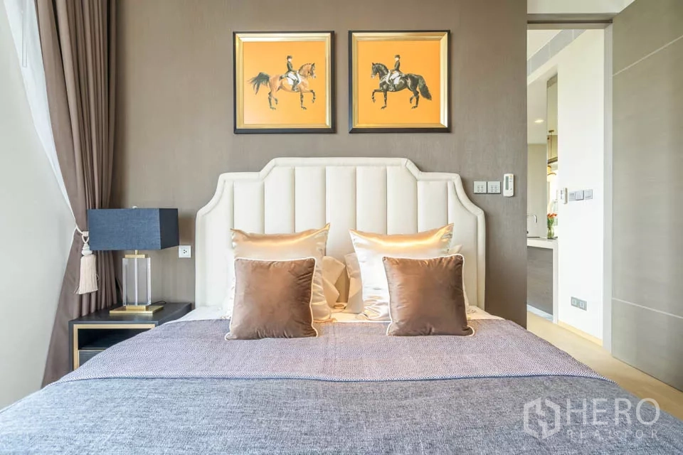 公寓 出租或出售在Bang Rak, Bangkok - 卧室软包床头与暖色装饰，时尚公寓氛围。