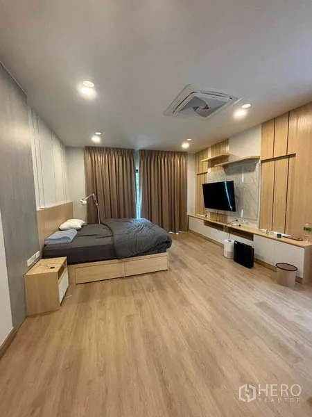 บ้าน ให้เช่าในMueang Nonthaburi, Nonthaburi - ห้องนอนมาสเตอร์พื้นไม้ ผนังทีวีพร้อมชั้นบิลท์อิน และเตียงคิง