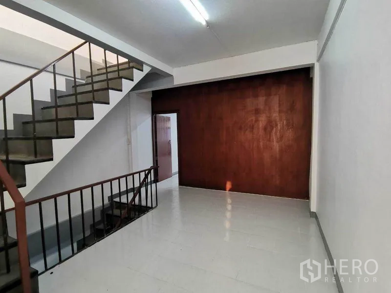 店屋 出租在Wang Thonglang, Bangkok - 一层空间，室内楼梯与木质特色墙面。