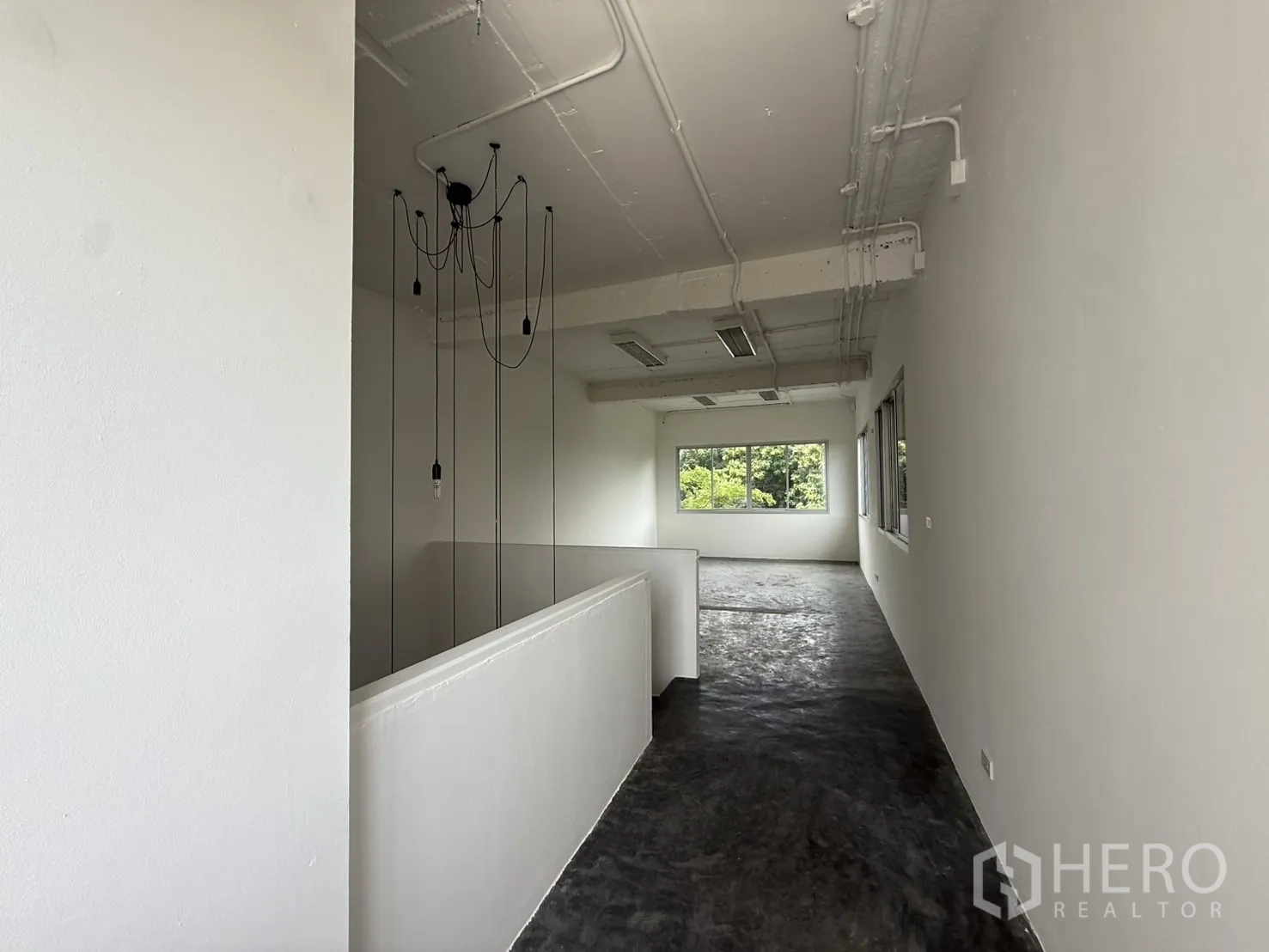 店屋 出租在Wang Thonglang, Bangkok - 高层走廊临楼梯间，吊灯与窗户引入采光。