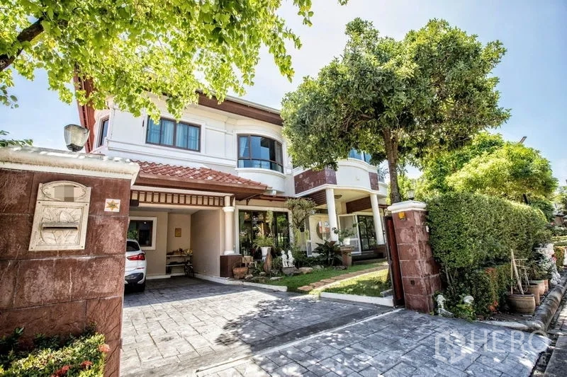 บ้าน ขายในLat Krabang, Bangkok - บ้านเดี่ยวสองชั้นหลังคากระเบื้อง พร้อมประตูรั้ว โรงจอดรถ และต้นไม้ใหญ่หน้าบ้าน