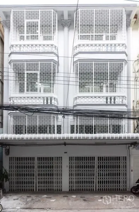 Home Office for sale in Bang Kho Laem, Bangkok - Multi-storey white home office facade with gated parking and grilled windows in Bang Kho Laem.