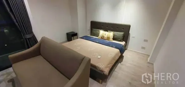 Detached House for rent in Prawet, Bangkok - Cozy bedroom with upholstered bed, sofa, and light wood flooring.