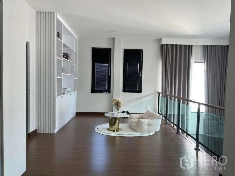 Detached House for rent in Bang Phli, Samut Prakan - Upper landing family area with glass balustrade and built-in shelving.