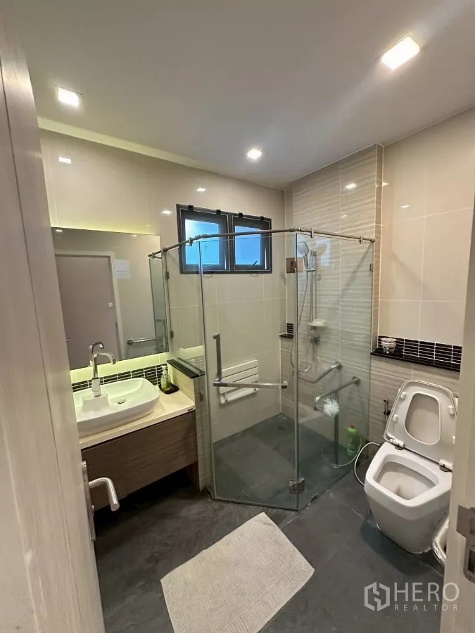 Detached House for sale in Bang Lamung, Chon Buri - Modern bathroom with glass shower enclosure and wall-hung toilet.
