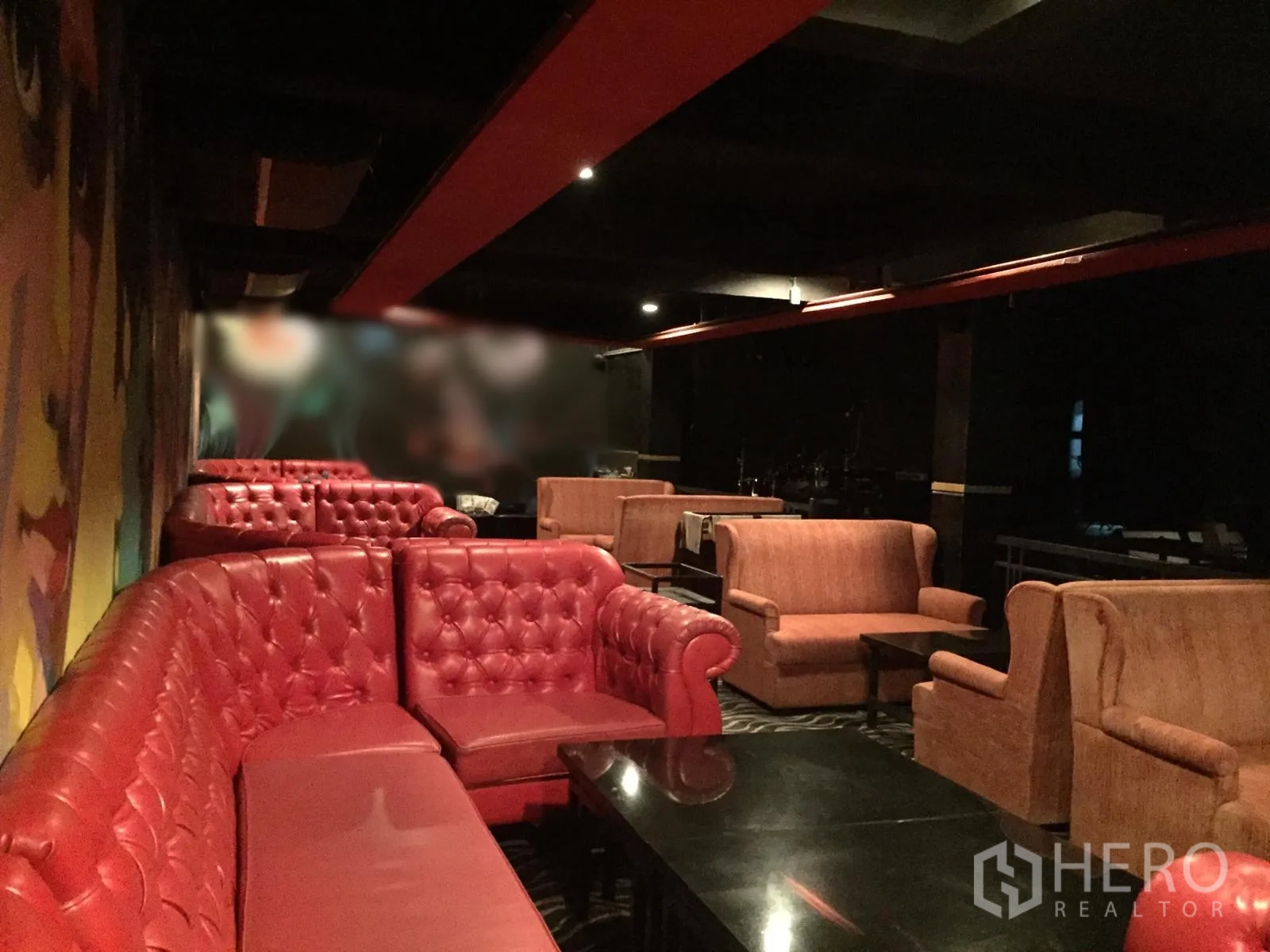 พื้นที่ขายปลีก ให้เช่าในWatthana, Bangkok - มุมเลานจ์โซฟาเชสเตอร์ฟิลด์สีแดงกับเก้าอี้นวม รอบโต๊ะกาแฟสีดำ