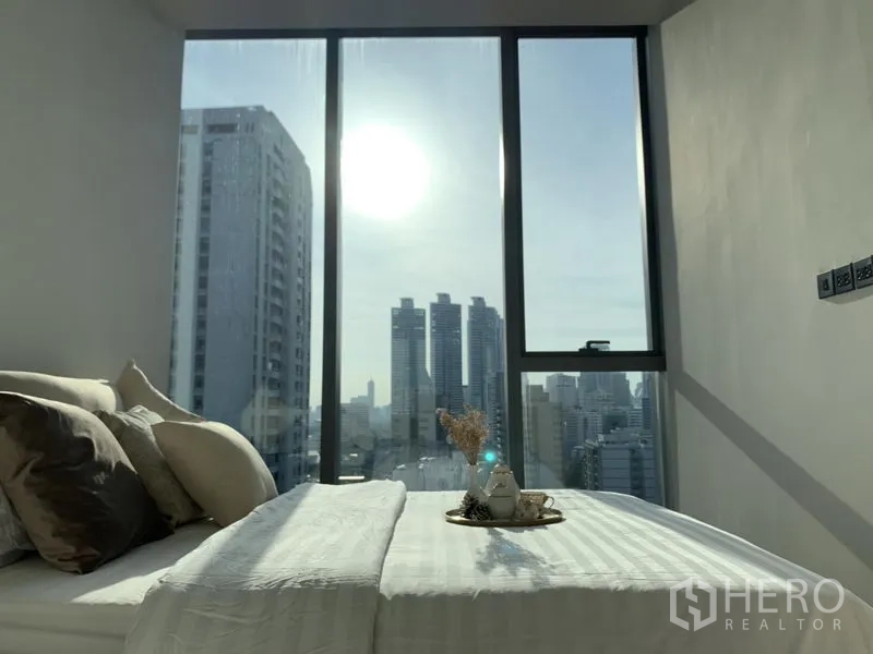 คอนโด ให้เช่าหรือขายในKhlong Toei, Bangkok - ห้องนอนที่สองพร้อมหน้าต่างบานใหญ่ โทนสีอบอุ่นและวิวเมืองกว้าง