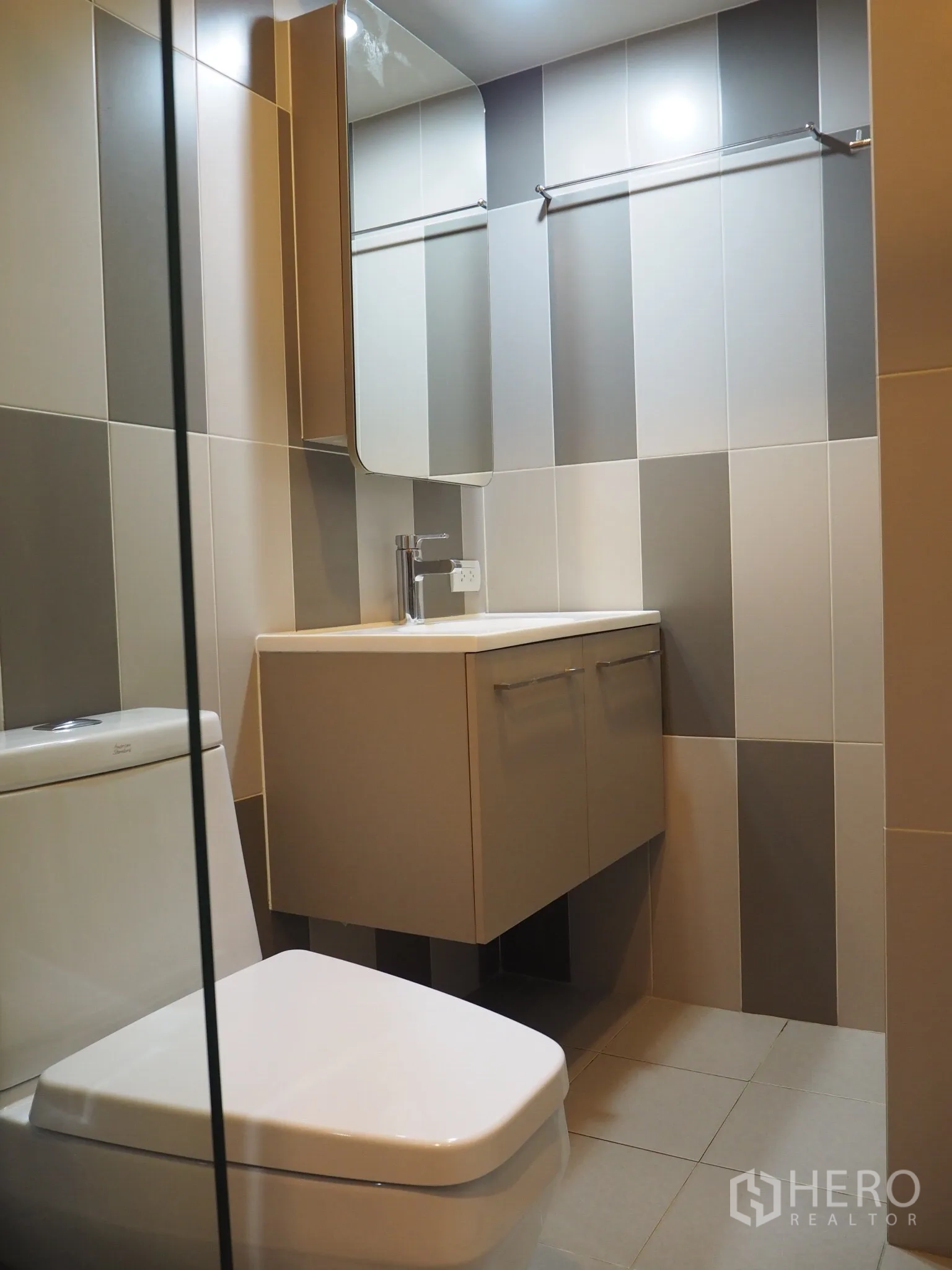 Condominium for rent in Phaya Thai, Bangkok - Contemporary bathroom with floating vanity, mirrored cabinet and striped tile walls.