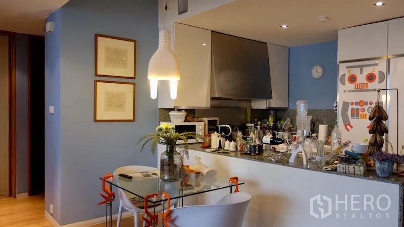 公寓 出租或出售在Sathon, Bangkok - 现代厨房带吧台、吊灯和玻璃餐桌。