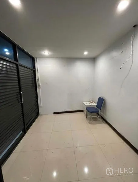 Shophouse for rent in Chatuchak, Bangkok - Compact office room with sliding glass door, tiled floor and ceiling lights.