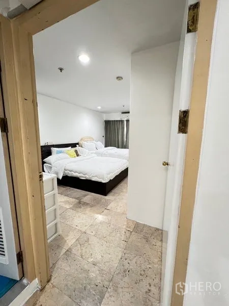 Condominium for rent in Ratchathewi, Bangkok - Bathroom with blue tile floor, glass shower enclosure and washing machine.