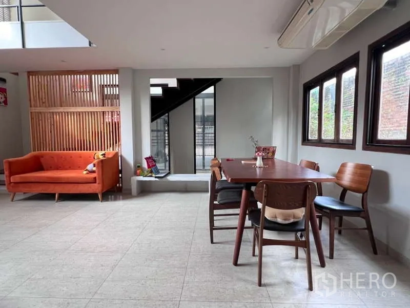 独立式住宅 出租在Lat Phrao, Bangkok - 开放式客餐厅，橙色沙发与木质餐桌