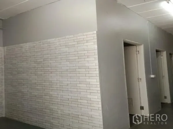 คลังสินค้า ให้เช่าในBang Phli, Samut Prakan - ผนังกระเบื้องลายอิฐสีขาว พร้อมประตูหลายบานเข้าสู่ห้องน้ำและพื้นที่เปลี่ยนชุด