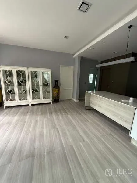 Detached House for rent or sale in Bang Bua Thong, Nonthaburi - Open-plan living and dining space with light wood floors, white display cabinets, and modern lighting.