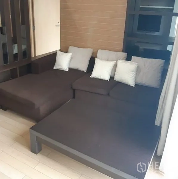 คอนโด ให้เช่าในKhlong Toei, Bangkok - พื้นที่นั่งเล่นกว้างพร้อมโซฟา L-Shape สีเข้มและโทนตกแต่งเรียบง่าย