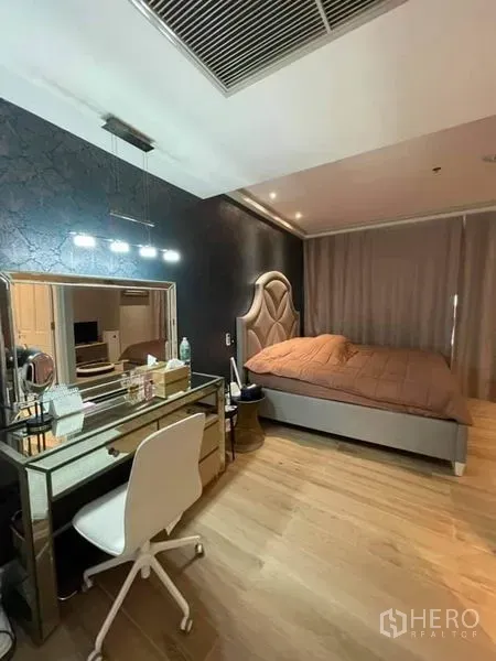 คอนโด ขายในPathum Wan, Bangkok - ห้องนอนอบอุ่นผนังลายเด่น เตียงหัวบุ และโต๊ะเครื่องแป้งกระจก