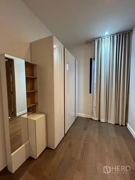 Detached House for rent in Bang Kapi, Bangkok - Walk‑in closet corridor with glossy wardrobes and mirror