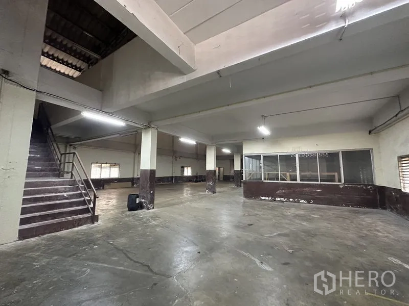 工厂 出租在Bang Bua Thong, Nonthaburi - 底层仓库空间，柱网布局，楼梯与玻璃隔间办公室
