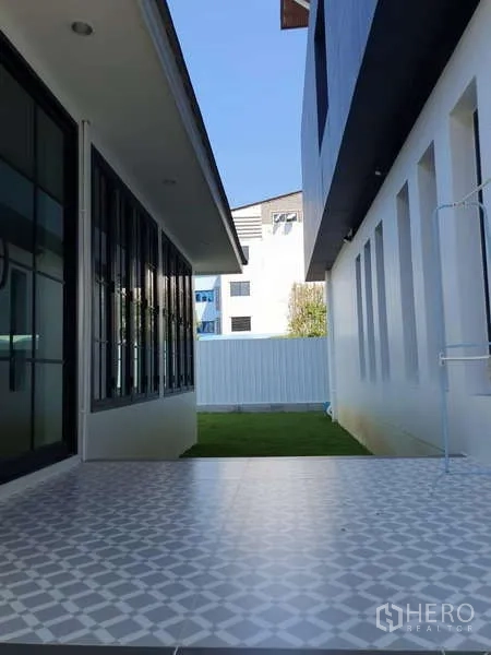 独立式住宅 出租在Phra Khanong, Bangkok - 侧院有花纹地砖的有顶露台，连接两翼建筑。