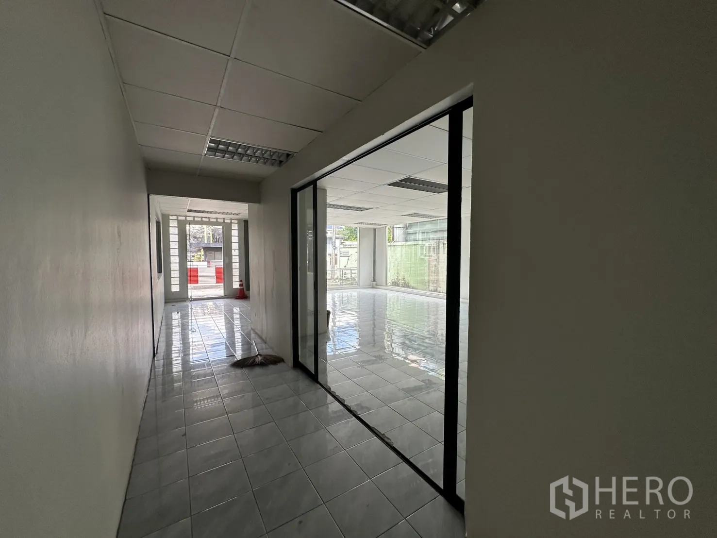 Warehouse for rent in Suan Luang, Bangkok - Hallway with glass partitions connecting to the front showroom.