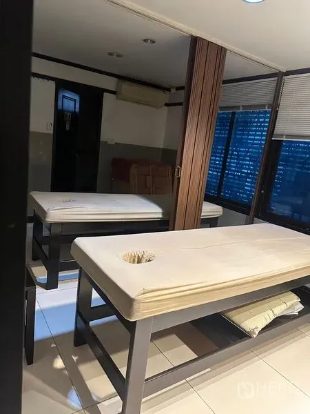 อาคารพาณิชย์ ให้เช่าในPhra Khanong, Bangkok - ห้องทรีตเมนต์สว่างพร้อมเตียงนวดสองตัว หน้าต่าง และฉากกั้น