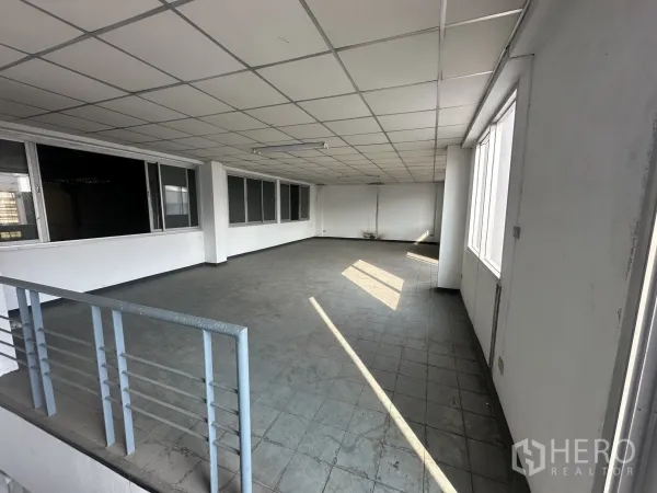 Factory for rent or sale in Khlong Luang, Pathum Thani - Spacious open-plan office floor with tiled flooring, drop ceiling and windows letting in natural light.