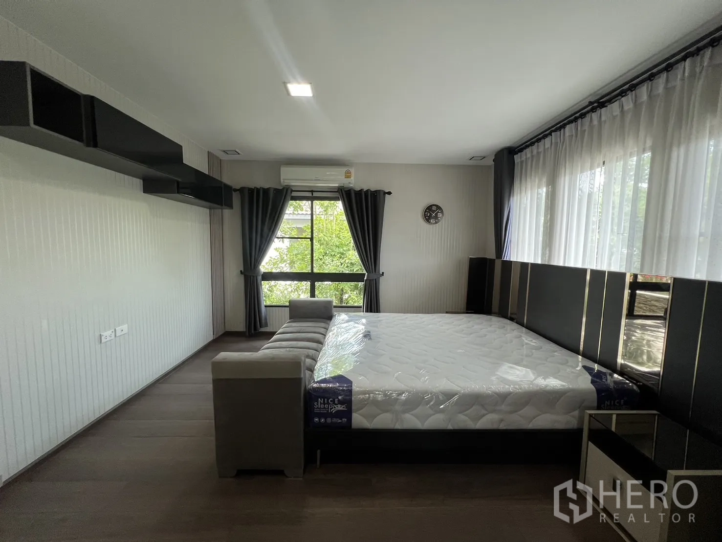 Detached House for rent in Bang Phli, Samut Prakan - Master bedroom view to windows with sheer curtains and dark drapes.