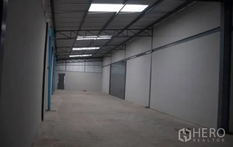 Warehouse for rent in Bang Phli, Samut Prakan - Long warehouse interior with skylight roof panels and concrete floor.